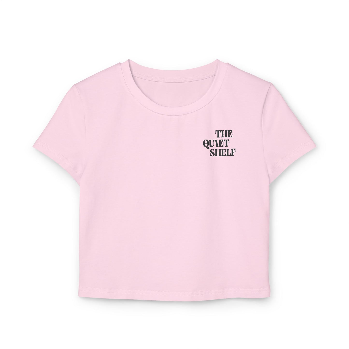 A pink cropped tee with 'THE QUIET SHELF' logo printed on the upper left chest area.