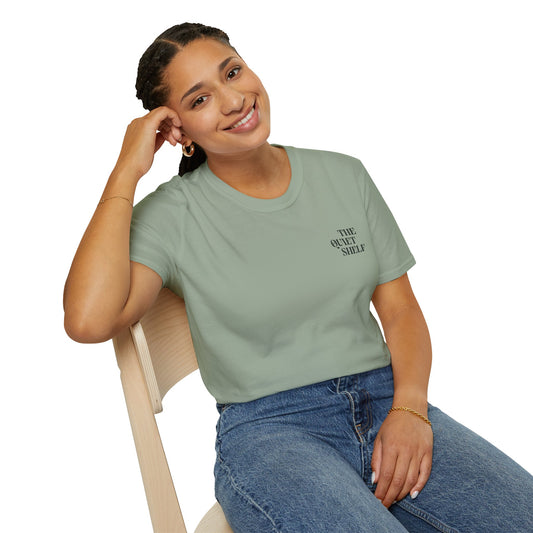 Woman wearing a light green t-shirt with text, sitting on a chair against a white background