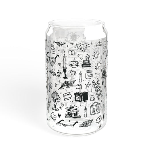 Clear glass tumbler with black line art illustrations on a white background