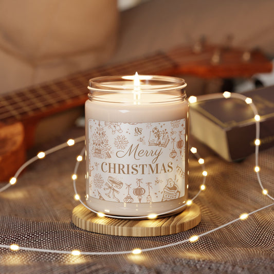 Candle with 'Merry Christmas' label on a wooden coaster surrounded by string lights and a guitar in the background.
