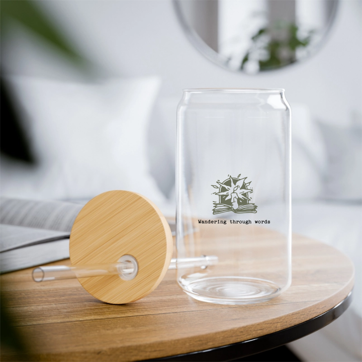 A clear glass with a wooden lid, featuring a custom design, alongside a straw, on top of a wooden table.