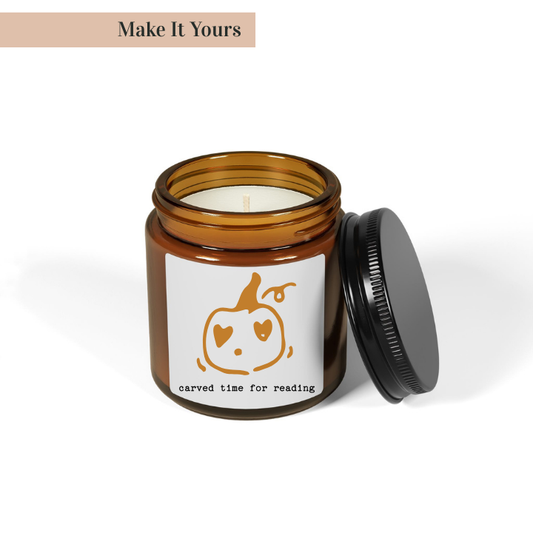 Candle in an amber jar with a white label featuring a pumpkin design on a white background.