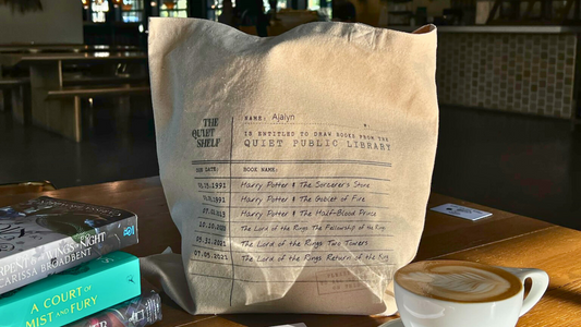 Customized book lover tote bag styled with fantasy books and latte on wooden café table