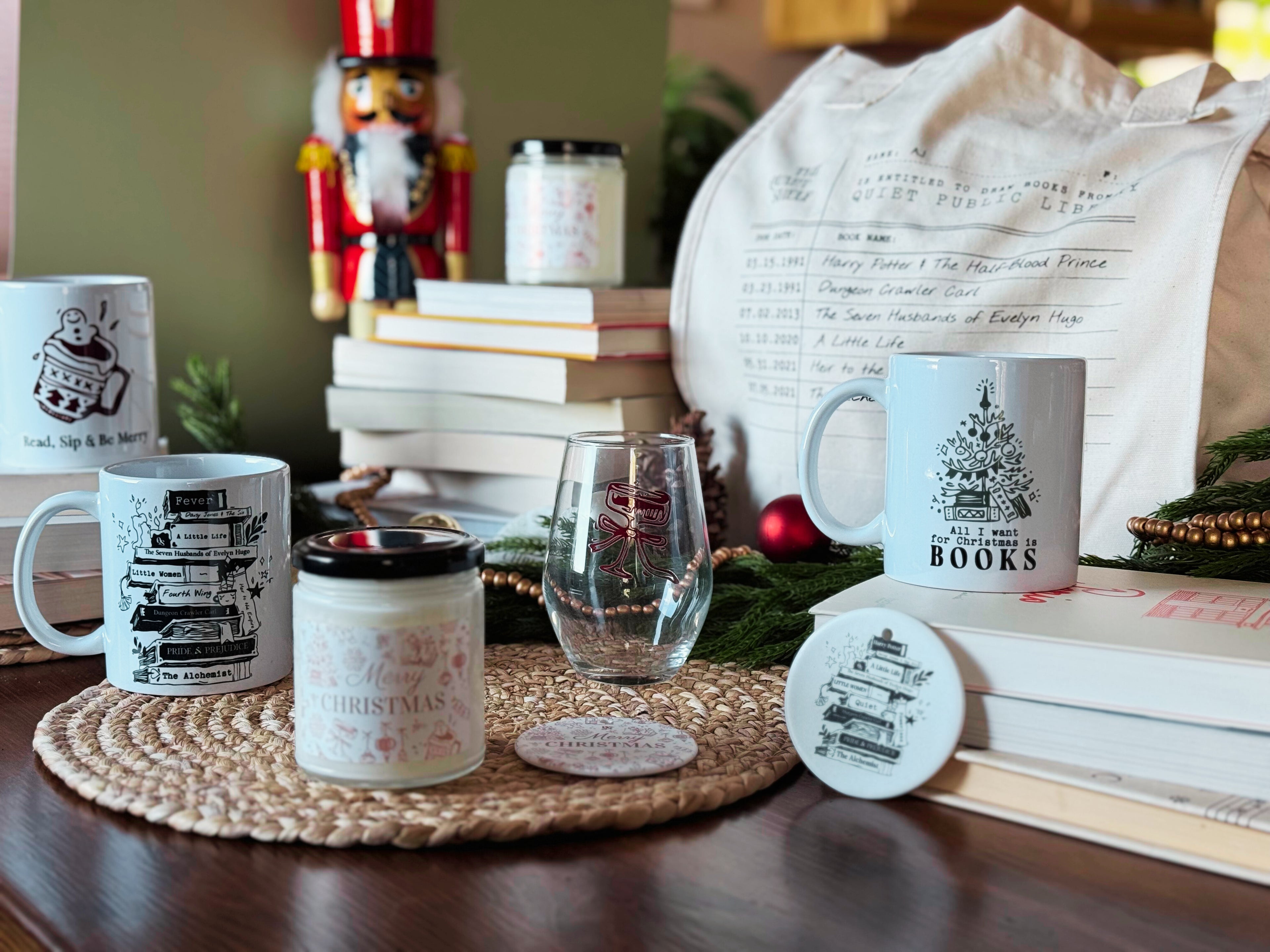 Table setting with mugs, candles, and books featuring Christmas-themed designs.