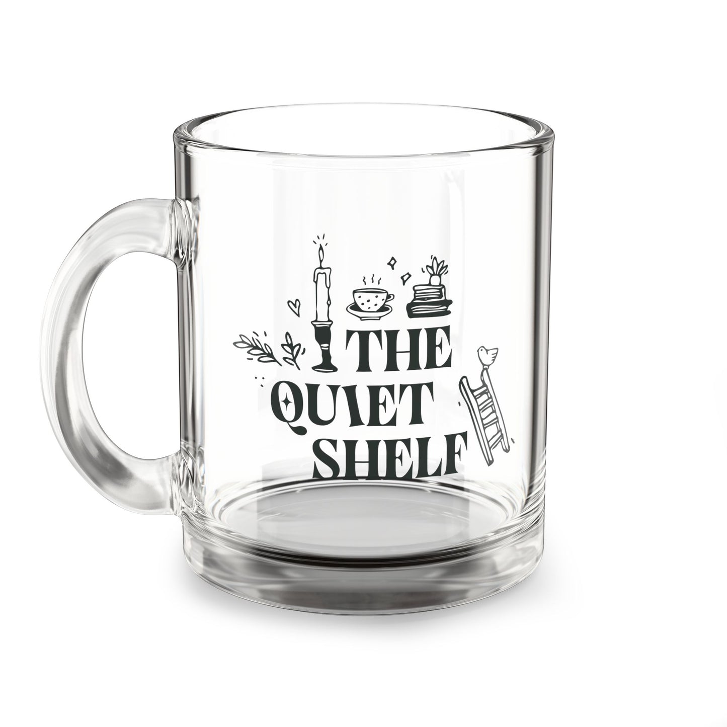A clear glass mug with 'THE QUIET SHELF' and other book-themed graphics and text printed on it.