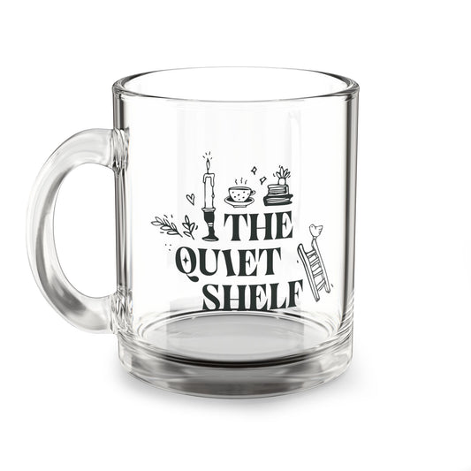 A clear glass mug with 'THE QUIET SHELF' and other book-themed graphics and text printed on it.