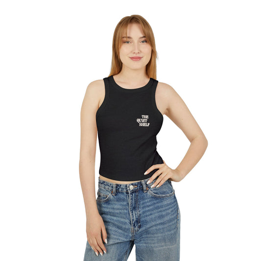 Woman wearing a black tank top and blue jeans on a white background