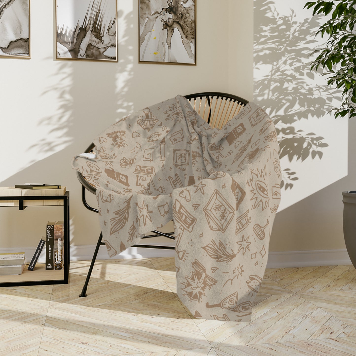 Patterned blanket draped over a chair in a room with light wood flooring and framed artwork on the wall.