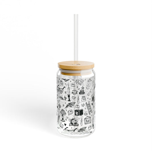 Clear tumbler with black illustrations, wooden lid, and straw on a white background