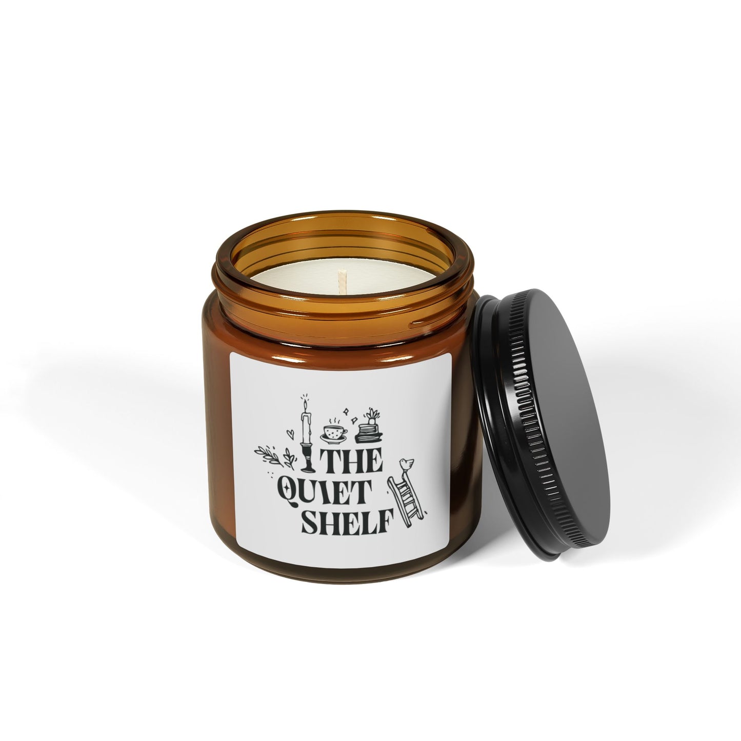 A soy candle in an amber glass jar with a black lid, featuring a minimalist label with bookish elements and the text 'THE QUIET SHELF'.