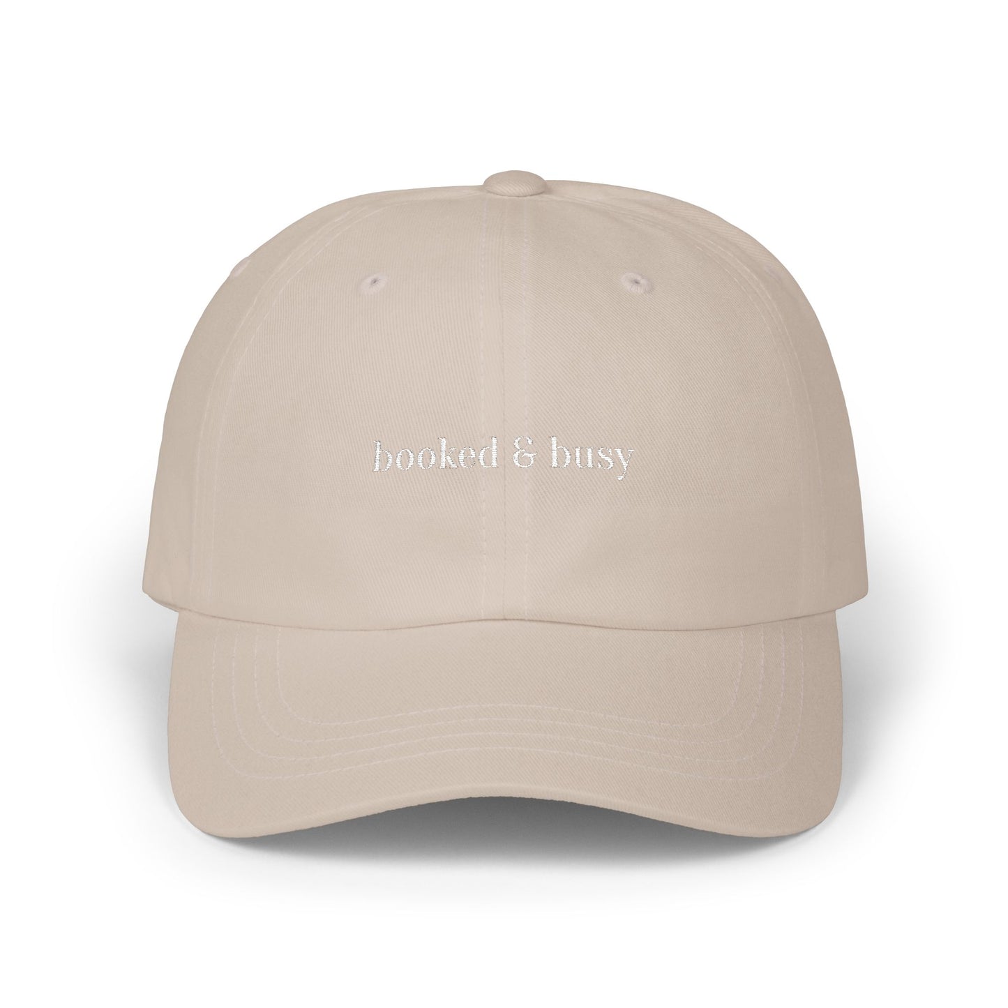 Beige cap with 'booked & busy' text on a white background