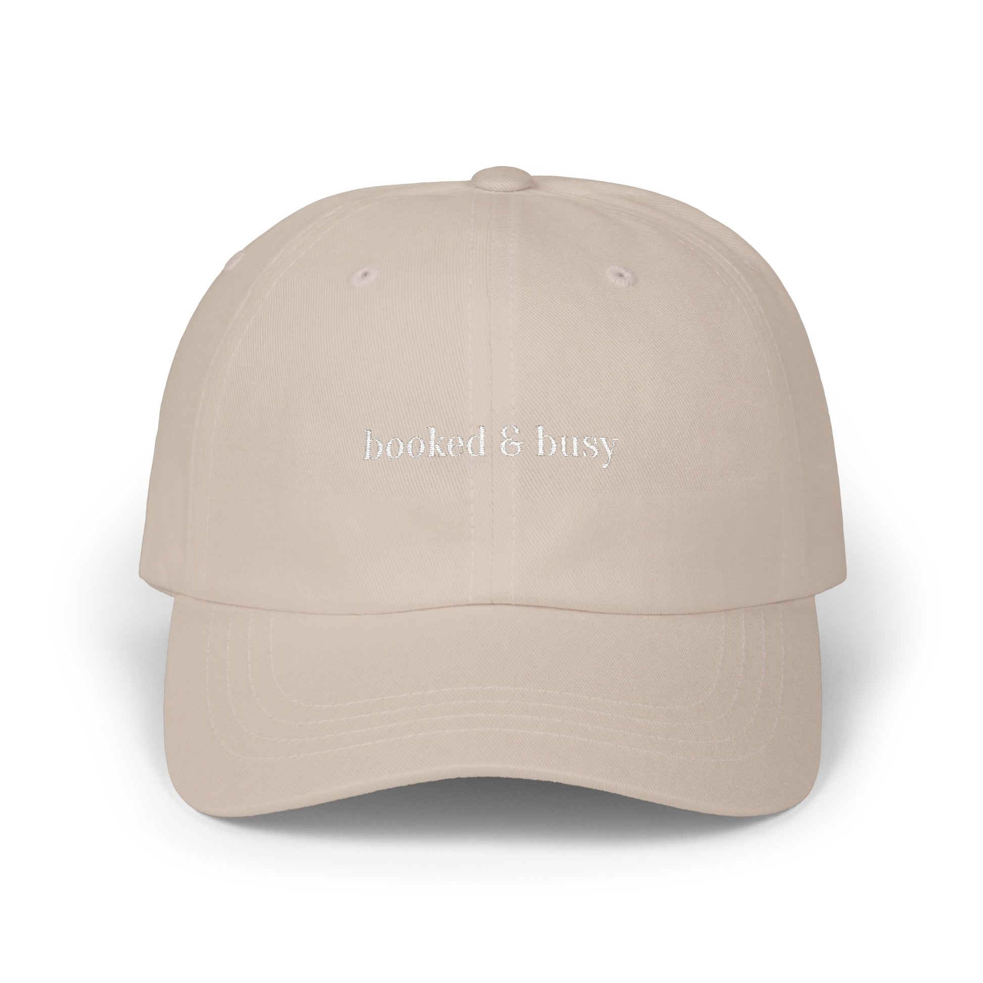 Beige cap with 'booked & busy' text on a white background