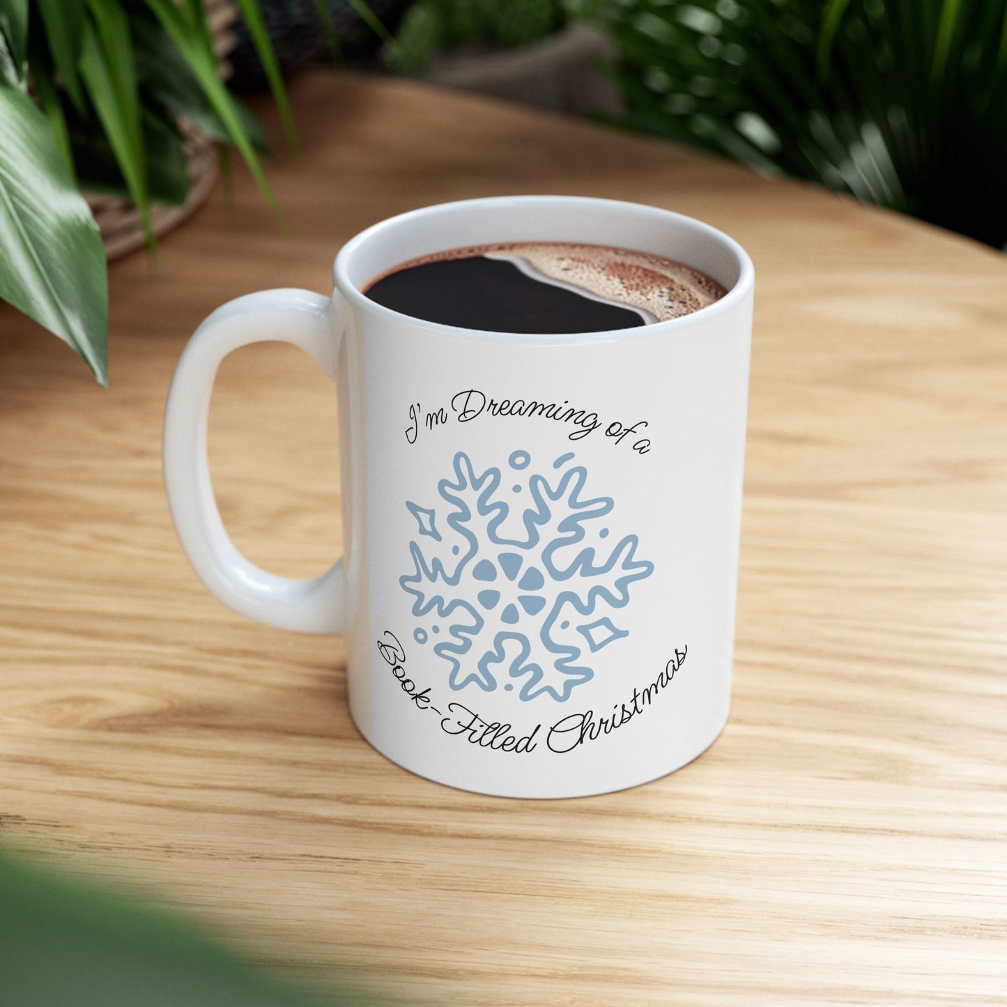 White mug with blue snowflake design and text on a wooden table