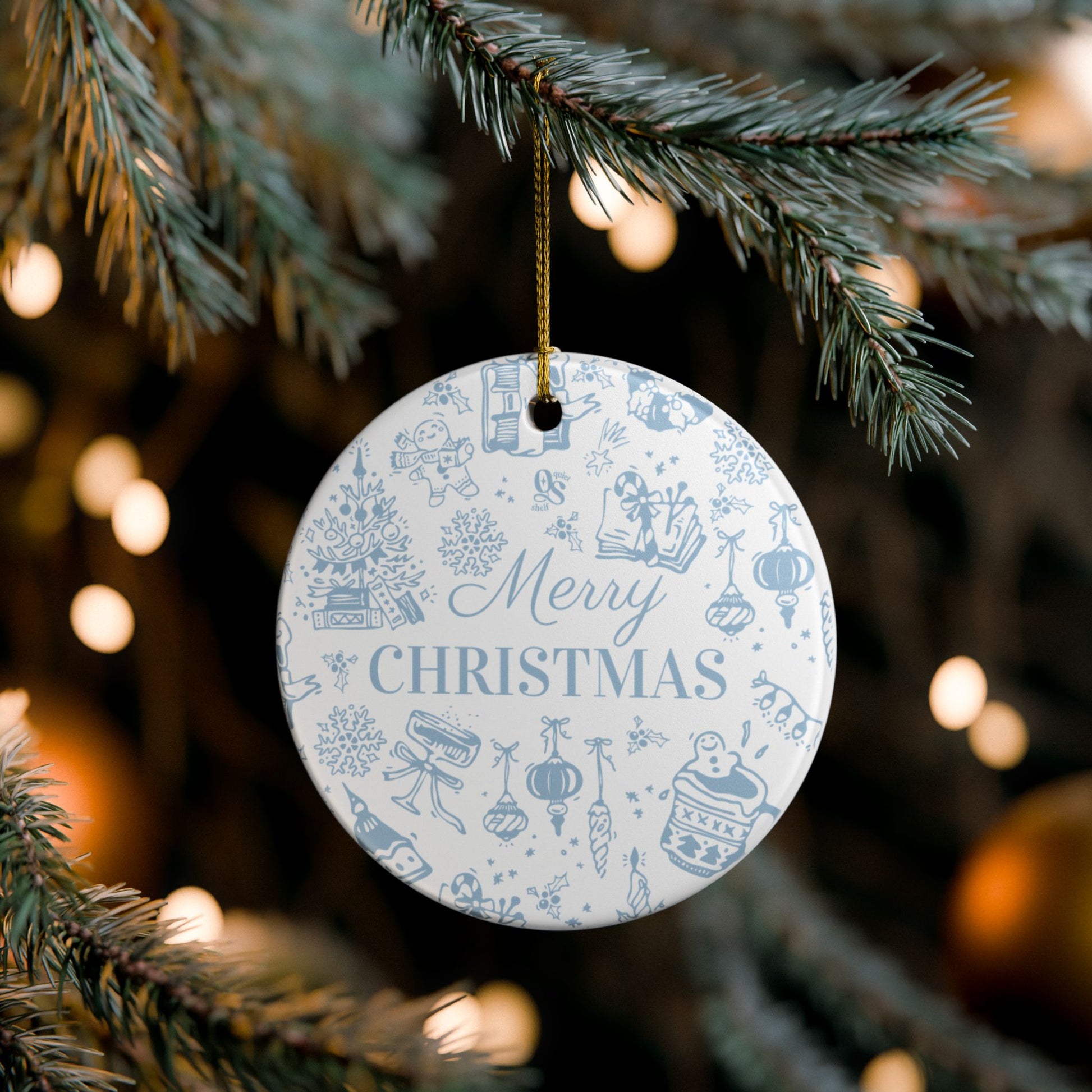 Round Christmas ornament with blue designs and 'Merry Christmas' text hanging on a tree.