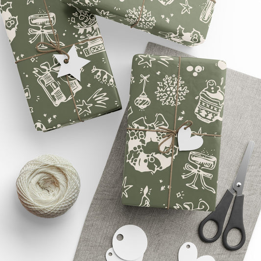 Green gift wrap with white patterns, scissors, and yarn on a gray surface