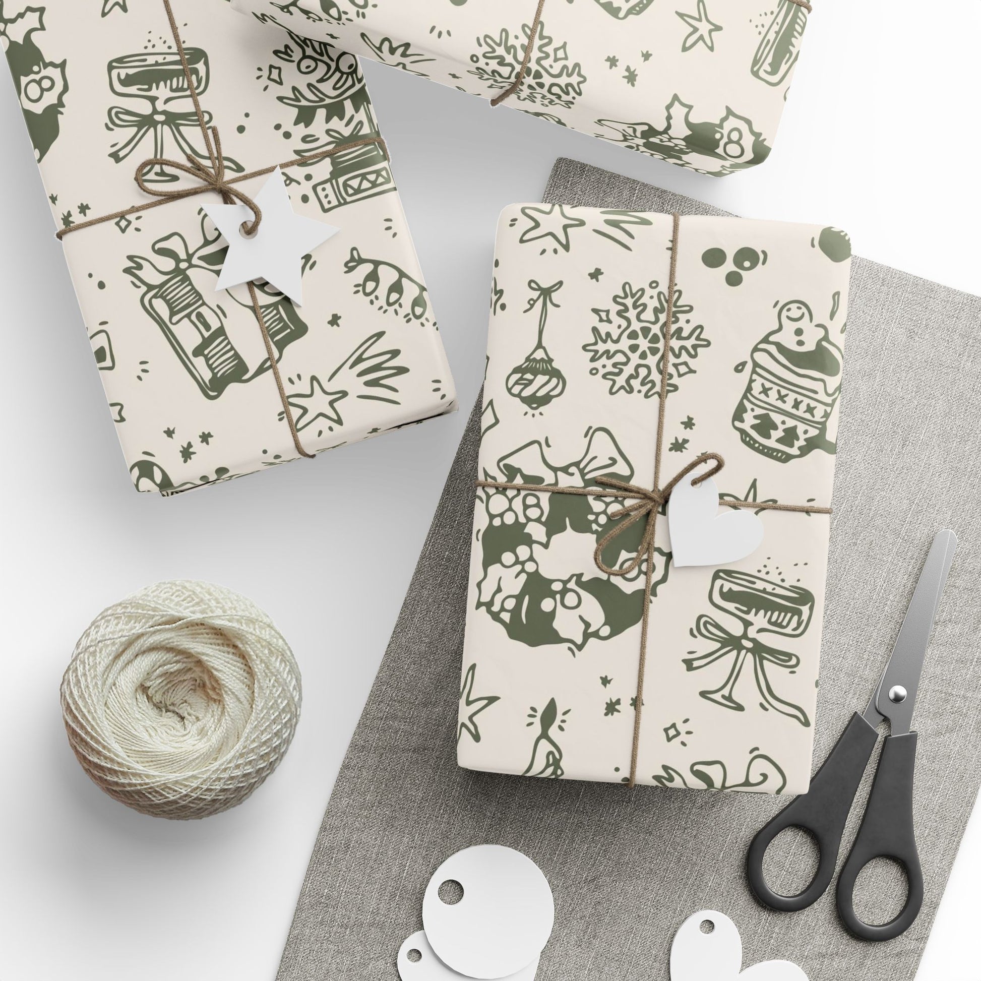 Gift boxes wrapped in patterned paper with scissors and yarn on a gray surface