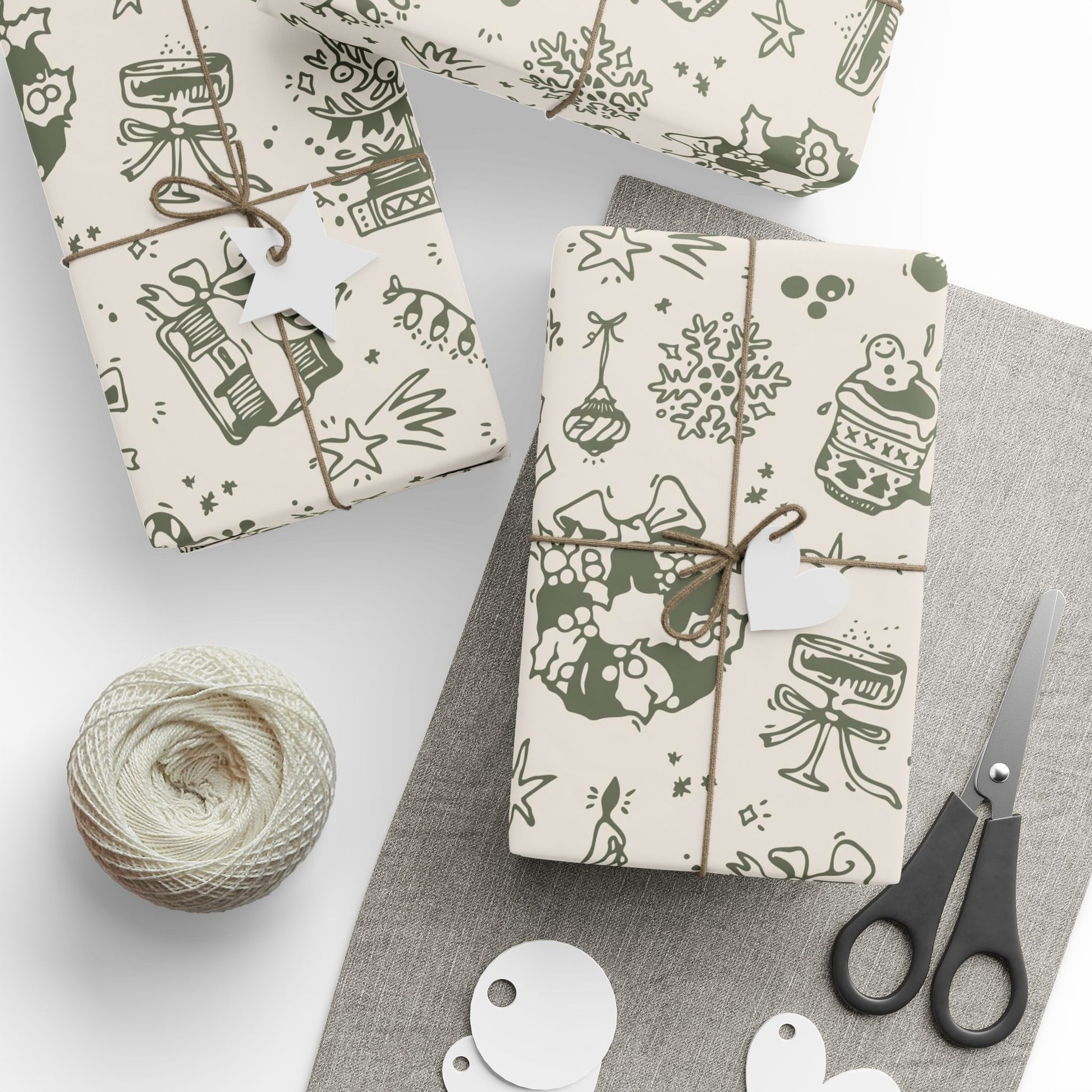 Gift boxes wrapped in patterned paper with scissors and yarn on a gray surface