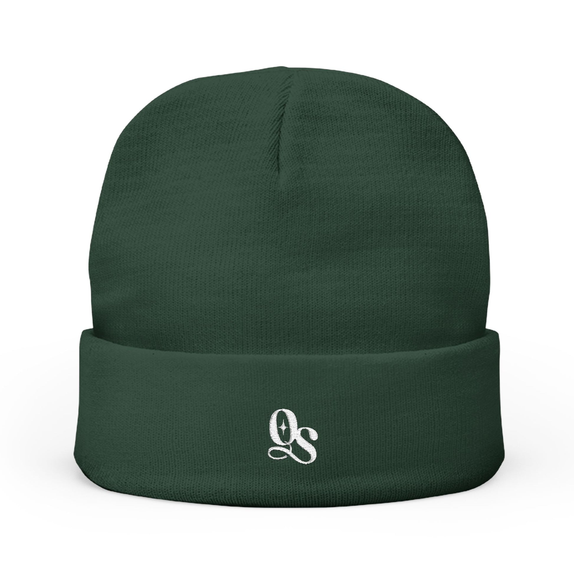 A green cuffed beanie with The Quiet Shelf's 'QS' monogram in embroidery on the front.