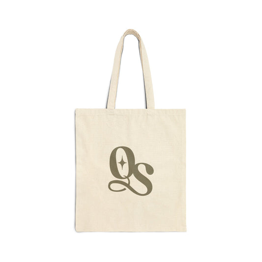 A beige cotton canvas tote bag with The Quiet Shelf's 'QS' monogram logo printed in the center.