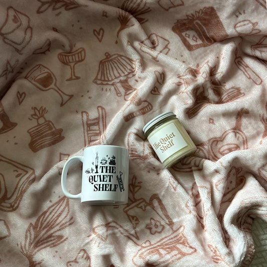 Mug and candle on a patterned blanket