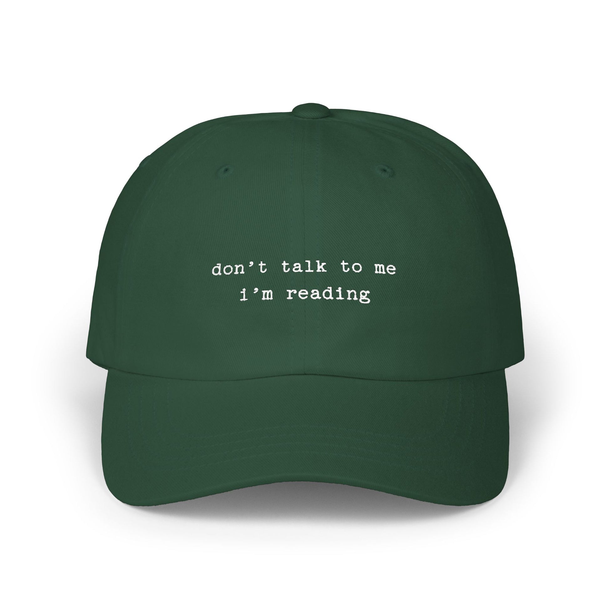 Green cap with 'don't talk to me I'm reading' text on a white background