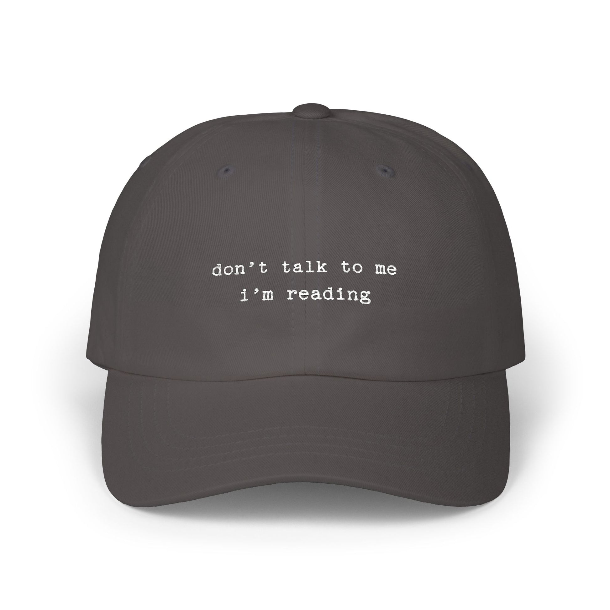 Dark gray cap with 'don't talk to me I'm reading' text on a white background