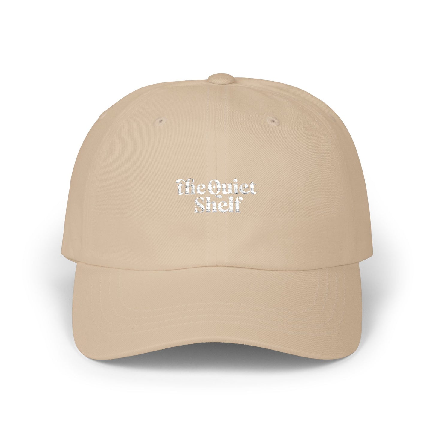A beige dad hat with 'The Quiet Shelf' logo embroidered in the center.