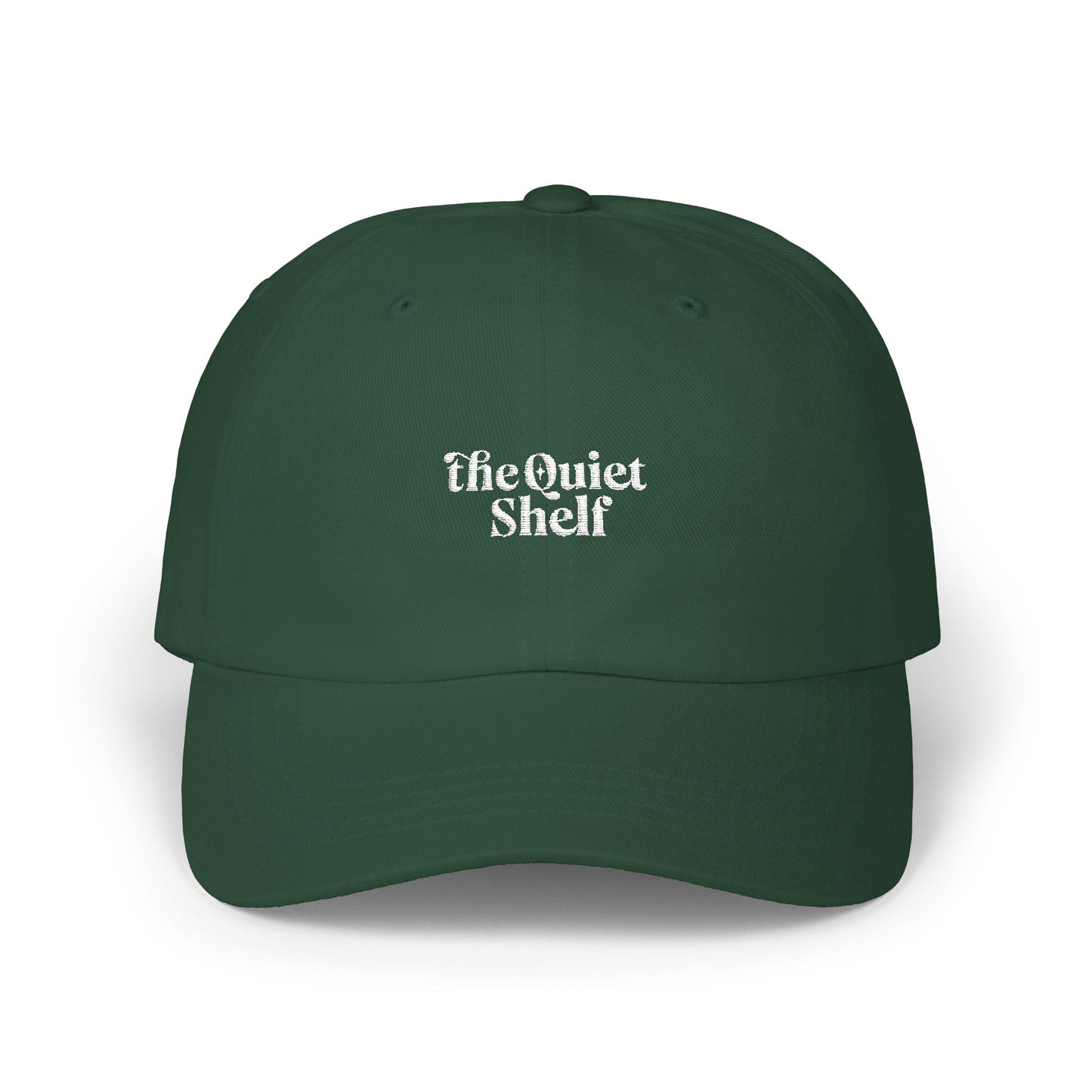 A green dad hat with 'The Quiet Shelf' logo embroidered in the center.