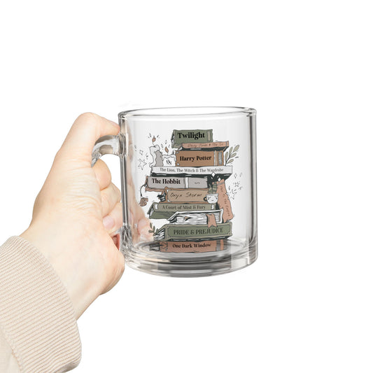 Clear glass mug with book design held by a hand on a white background