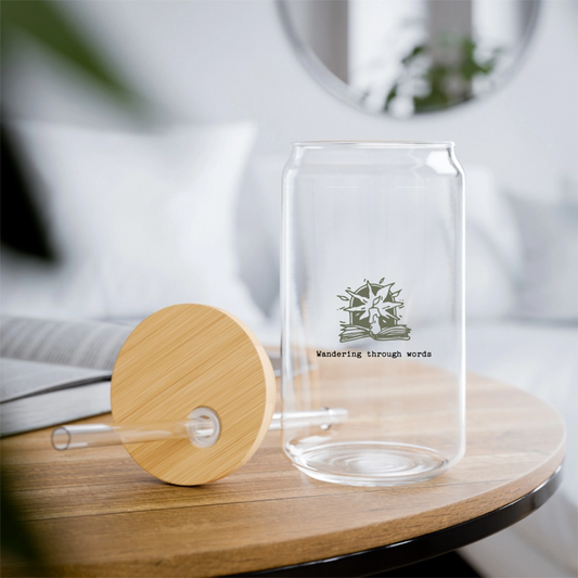 A clear glass with a wooden lid, featuring a custom design, alongside a straw, on top of a wooden table.