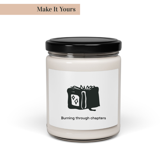 A soy candle in a clear glass jar with a black lid, featuring a custom label with book-themed artwork and text that reads 'Burning through chapters'. The jar is labeled 'Make It Yours'.