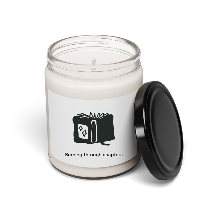 A soy candle in a clear glass jar with a black lid, featuring a custom label with book-themed artwork and text that reads 'Burning through chapters'. The jar is labeled 'Make It Yours'.