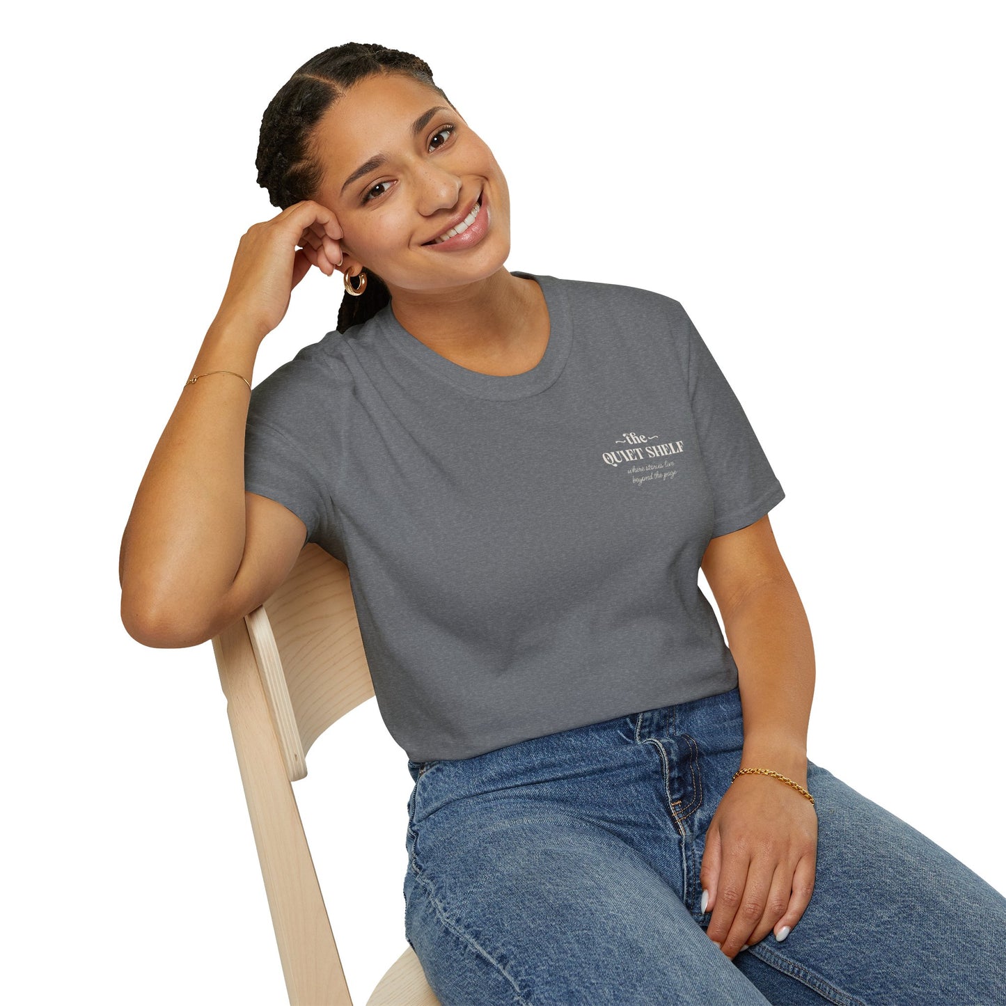 Woman wearing a gray t-shirt with a logo, sitting on a chair against a white background