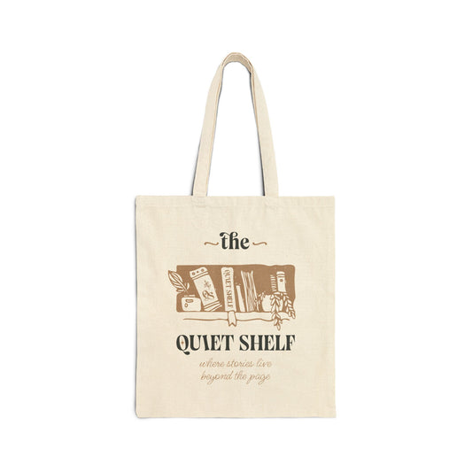 A beige cotton tote bag with 'the Quiet Shelf' logo printed in brown.